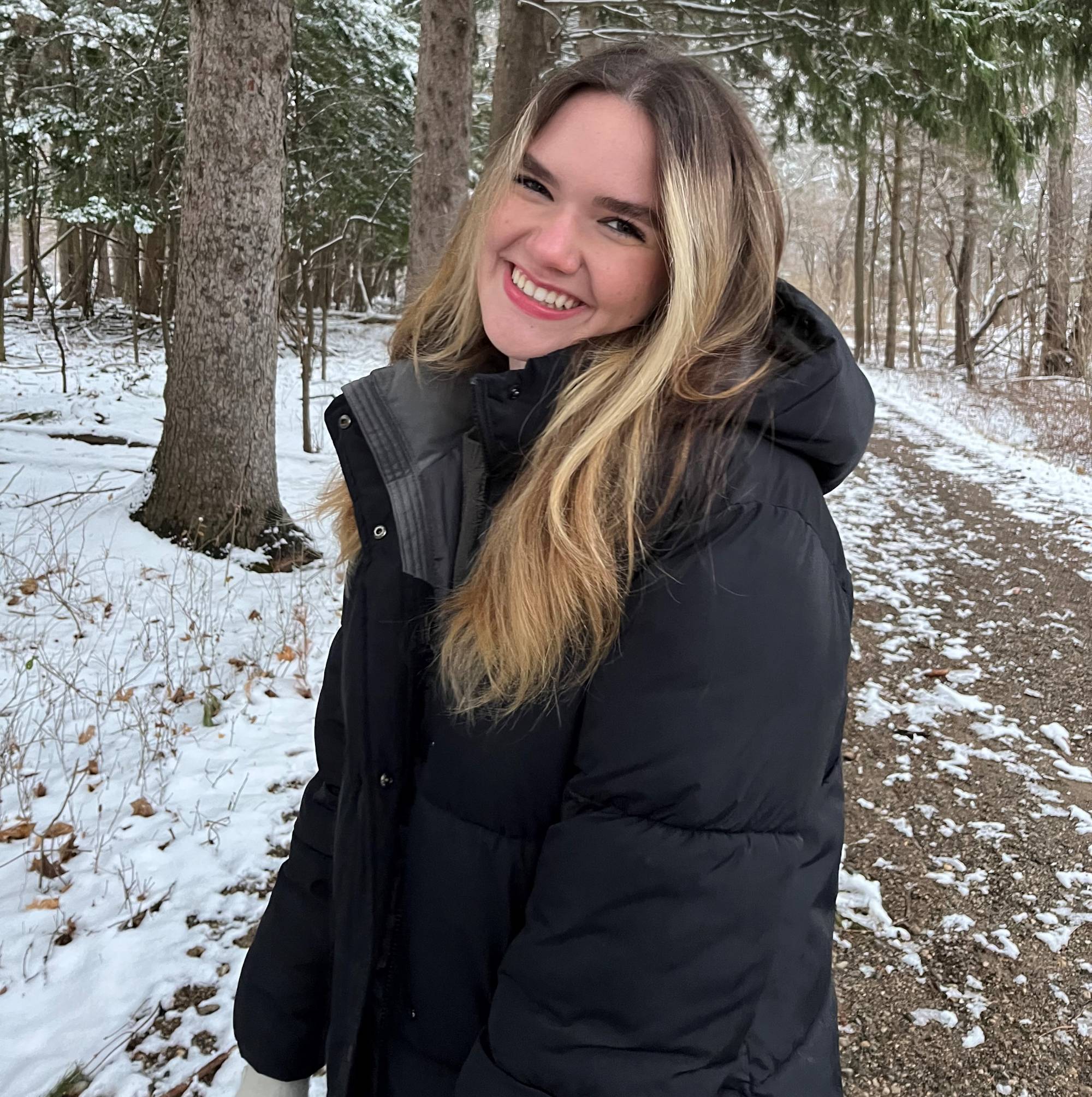 Melanie Siebert posing in front of trees in winter